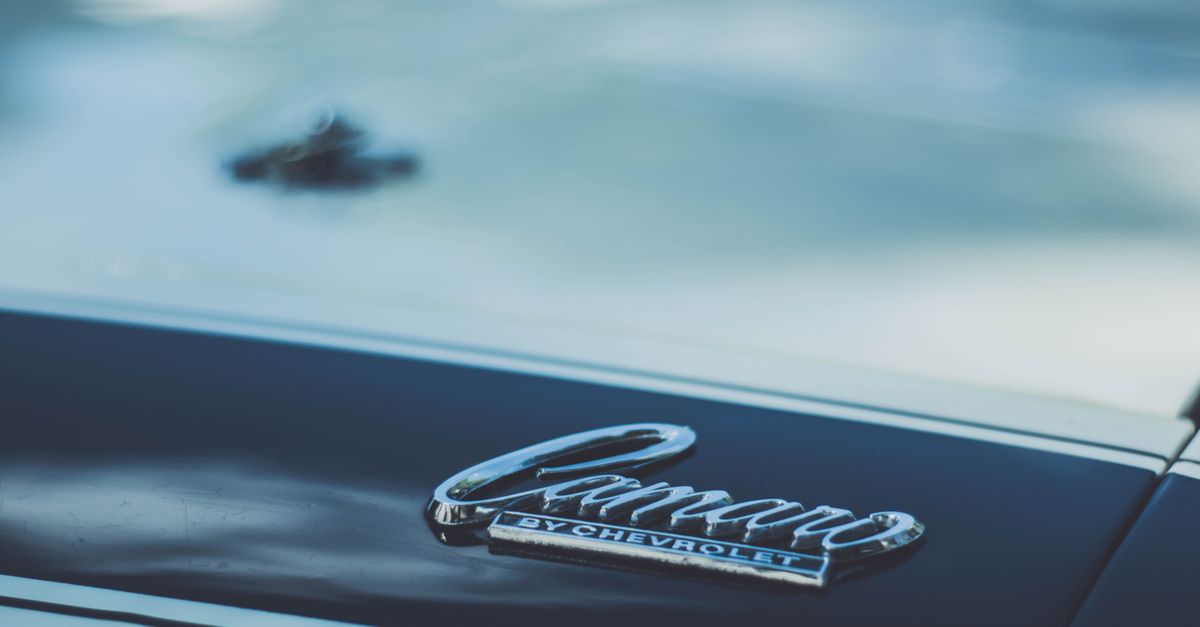 Detailed view of a Chevrolet Camaro emblem on a car hood, perfect for automotive enthusiasts.