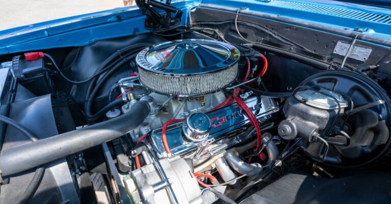 Detailed view of a Chevrolet car engine inside a classic vehicle's hood, blue exterior.