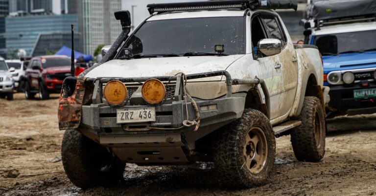 Mud-covered 4x4 truck participating in an off-road adventure event in Pasig City, Philippines.