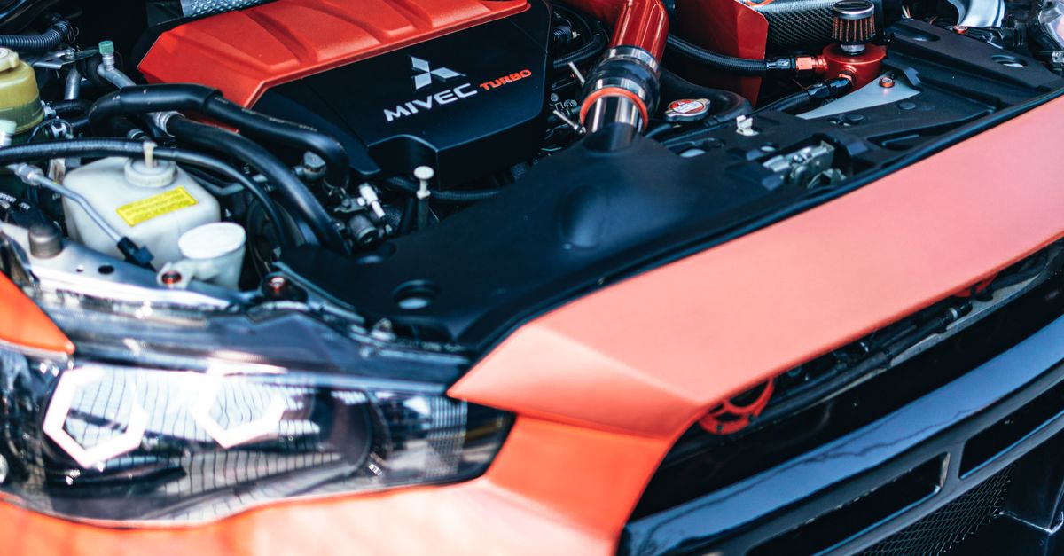 Detailed close-up of a high-performance car engine with red accents under the hood.
