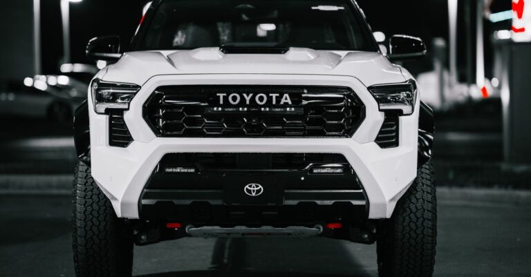 A Toyota truck captured at night in a city setting, displaying its bold front design.