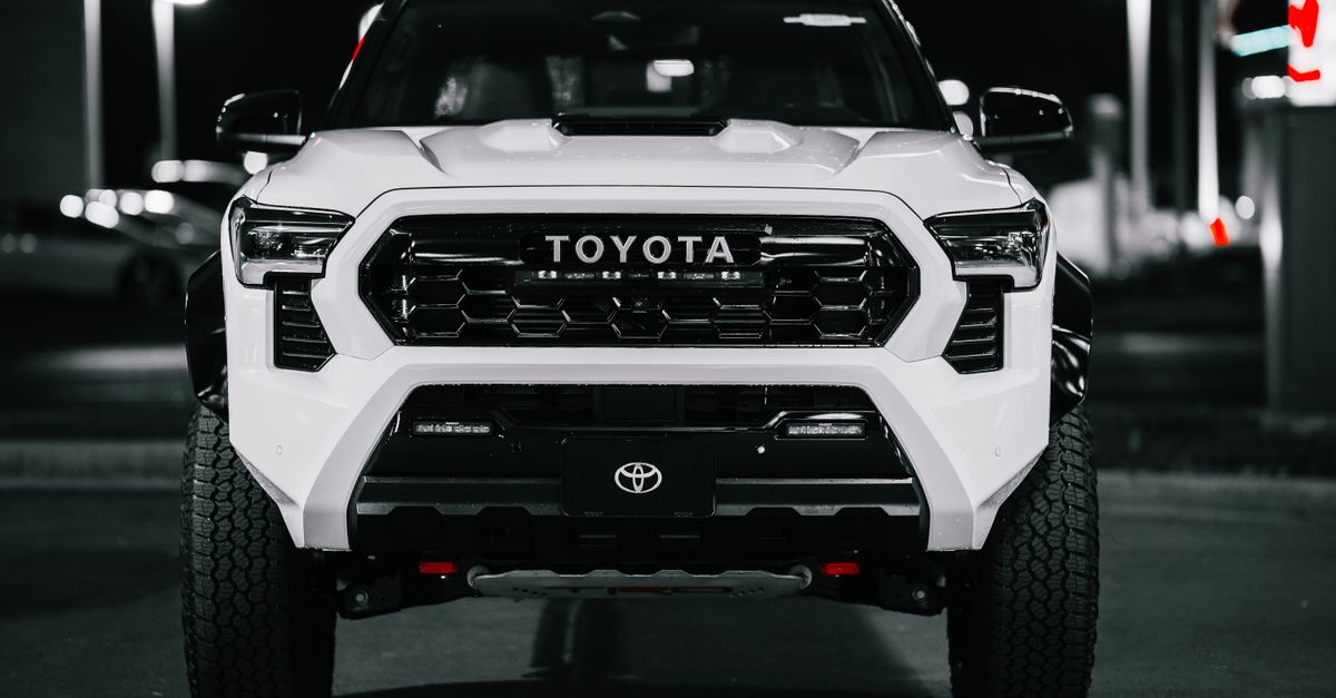 A Toyota truck captured at night in a city setting, displaying its bold front design.