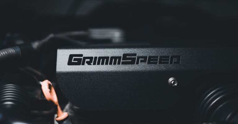 Detailed view of a car engine featuring Grimmspeed components and metal parts.