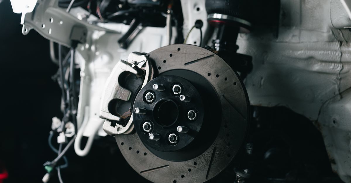 Detailed view of a vehicle's disc brake system with caliper, showcasing automotive technology.