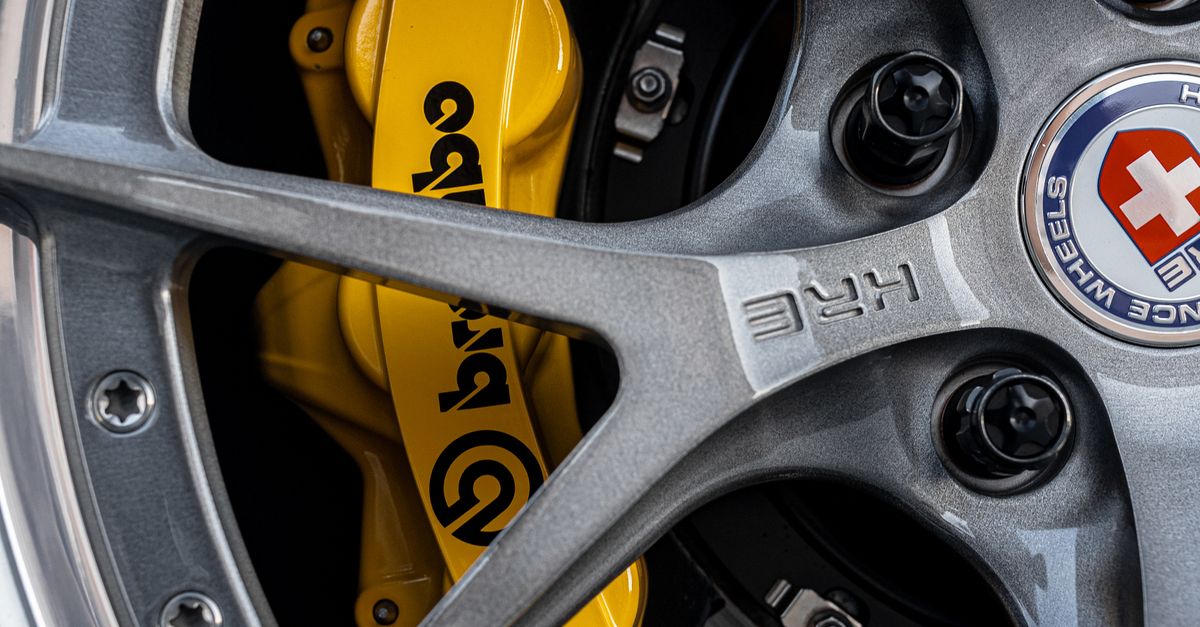 Detailed close-up of a custom car wheel with yellow brake caliper.