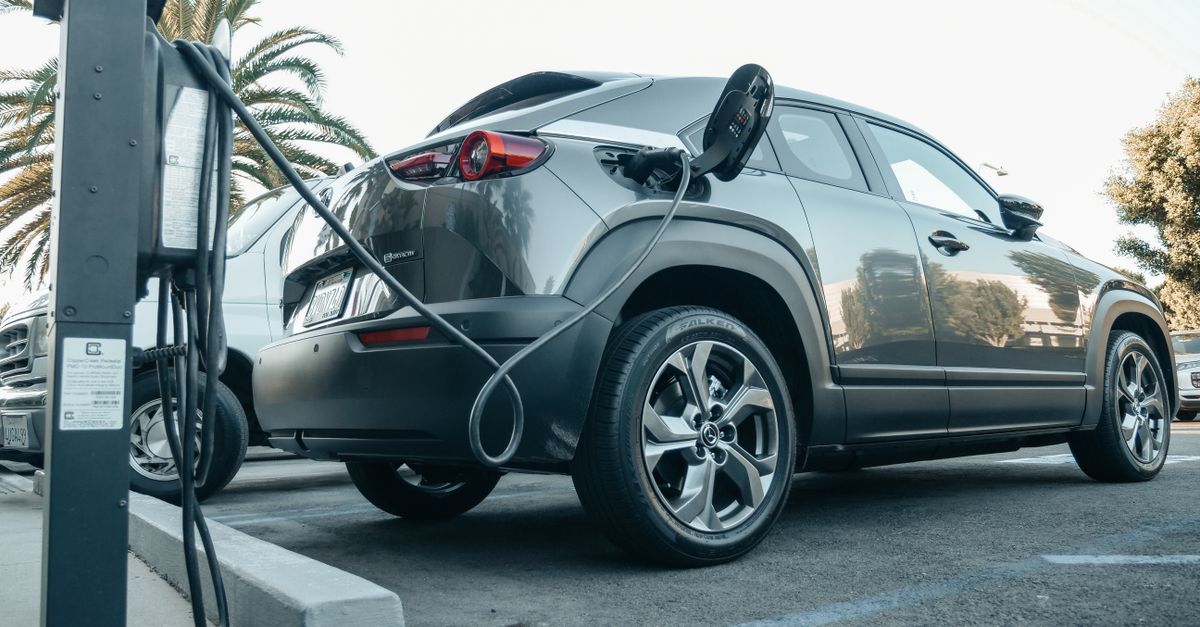 Modern electric vehicle charging at an outdoor station in daylight.