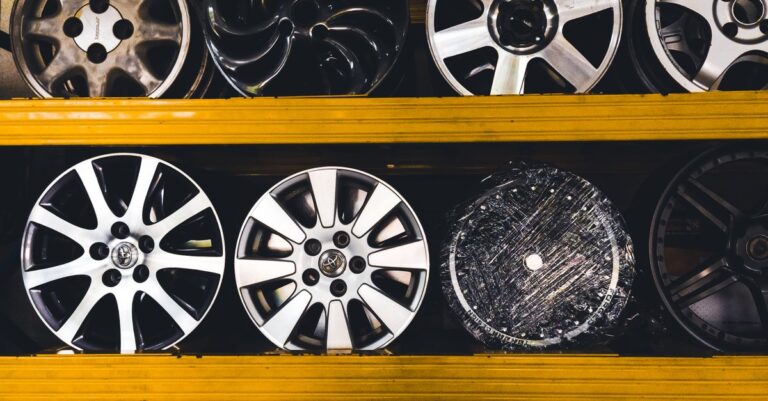 Vertical shot of various car rims displayed on shelves in Malaysia, showcasing different designs.