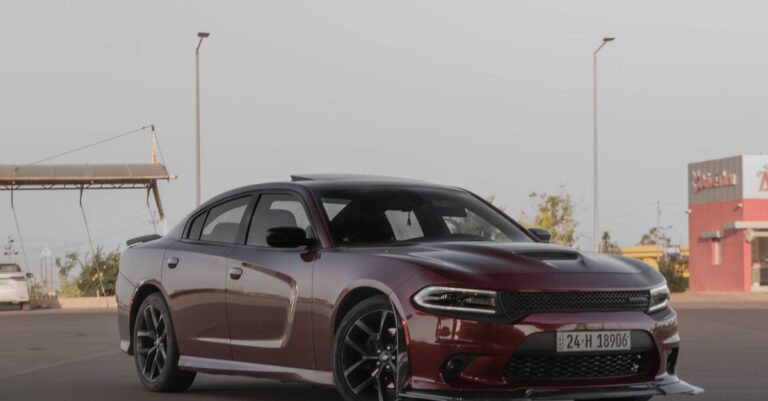 A stylish dark red Dodge Charger parked in an urban area, showcasing sleek design and power.